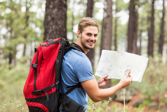 年轻的英俊的徒步旅行者地图