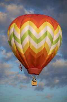橙色黄色的热空气气球浮动云