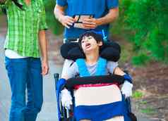 禁用孩子轮椅在户外护理人员家庭