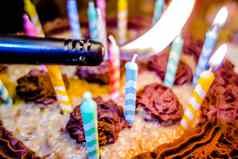 照明色彩斑斓的蜡烛生日蛋糕