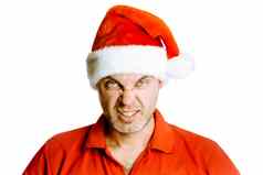 不剃须的愤怒的男人。红色的衬衫圣诞老人帽子工作室隔离