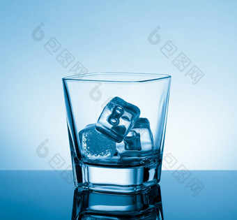 空玻璃威士忌黑色的表格反射冰光蓝色的色彩背景