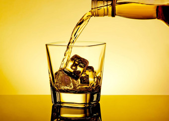 酒保倒威士忌玻璃表格反射温暖的色彩大气