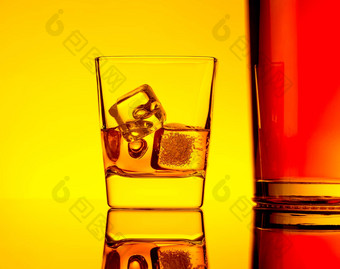 玻璃威士忌冰多维数据集瓶表格反射温暖的黄色的色彩大气