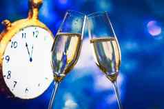 一年圣诞节午夜香槟长笛使干杯蓝色的散景时钟