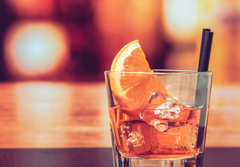 玻璃斯普利茨开胃酒阿培罗尔鸡尾酒橙色片冰多维数据集酒吧表格古董大气背景