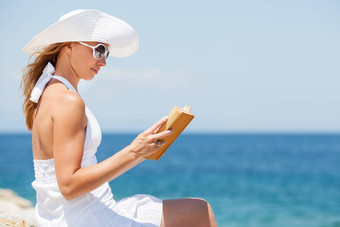 年轻的女人阅读书海滩