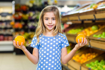微笑年轻的女孩持有橙子