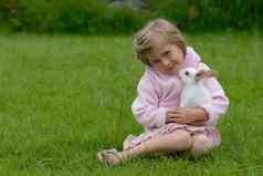 可爱的小女孩粉红色的有爱心的白色兔子