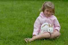 可爱的小女孩粉红色的有爱心的白色兔子