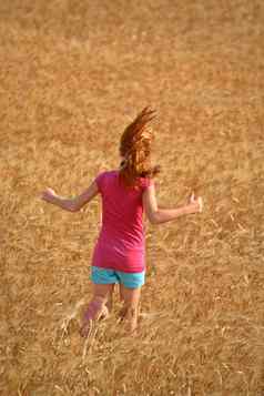 红色头发的人女孩运行萨斯喀彻温省小麦场