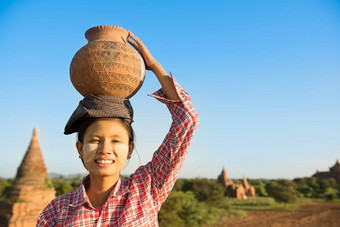 亚洲传统的女农民携带粘土能头