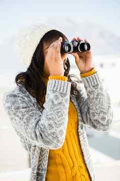 微笑女人穿冬天衣服双筒望远镜