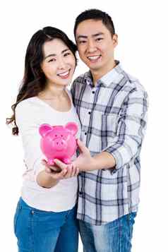 肖像快乐微笑夫妇持有小猪银行