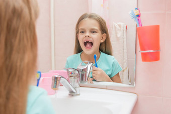 一年女孩开放口<strong>对待</strong>牙齿反射镜子浴室