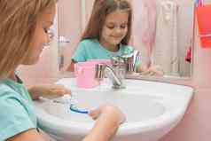 女孩清洁牙齿挤压牙膏管牙刷