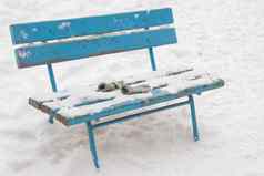 白雪覆盖的板凳上谎言被遗忘的儿童连指手套