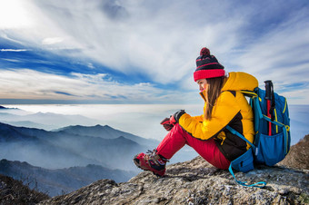 年轻的女人坐着山高山