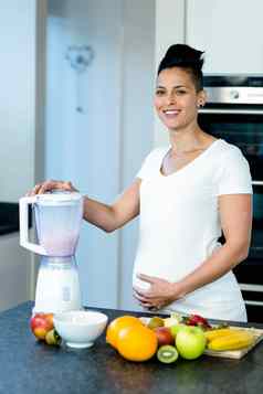 怀孕了女人准备水果汁搅拌机
