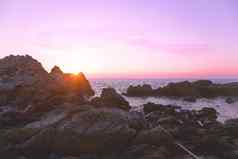 岩石海滩紫色的日落