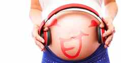 复合图像怀孕了女人持有耳机撞