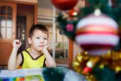 梦幻男孩坐着背景圣诞节树写列表