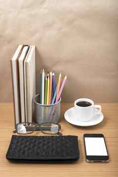 办公室桌子上咖啡电话堆栈书眼镜钱包