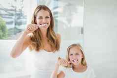 肖像快乐妈妈。女儿刷牙牙齿