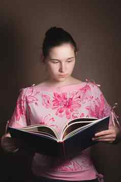年轻的美丽的女孩阅读书