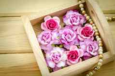 古董粉红色的玫瑰珍珠项链木背景