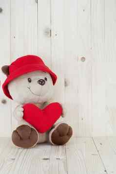 熊爱穿红色的他持有红色的心休息木墙
