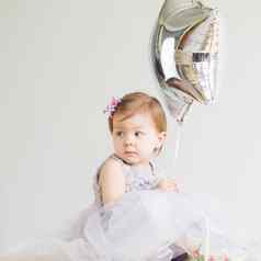 婴儿女孩持有银星形的气球