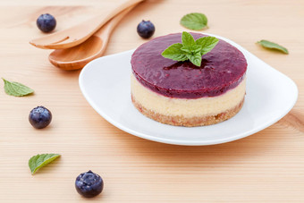 蓝莓芝士蛋糕新鲜的薄荷叶子木背景