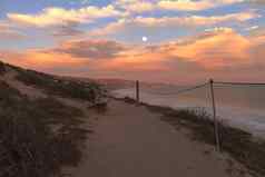 完整的月亮水晶湾海滩海岸线板凳上日落
