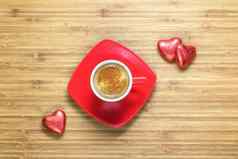 心形状的糖果包装明亮的红色的箔说谎木纹理杯咖啡背景浪漫的主题