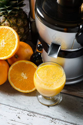 榨汁机橙色汁玻璃木桌子上