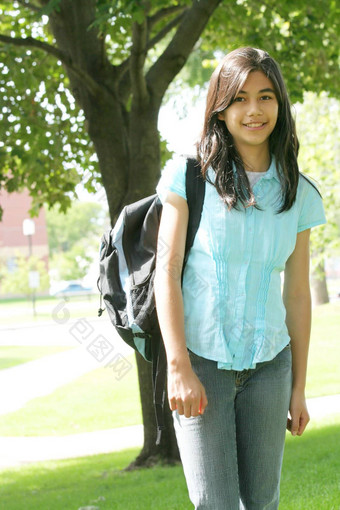 年轻的青少年女孩站背包树微笑
