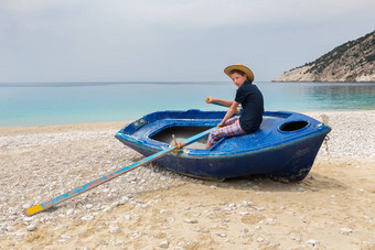 十几岁的男孩划船船希腊海滩
