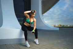 有吸引力的健身女孩锻炼现代城市区域日落