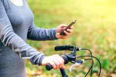 女人发短信持有自行车公园