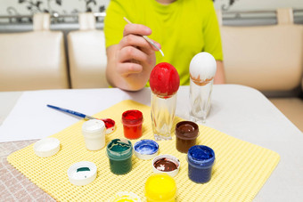 男孩油漆刷复活节鸡蛋
