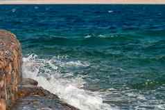 照片美丽的清晰的绿松石海海洋水表面涟漪明亮的飞溅石头海景背景水平图片