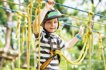 孩子们攀爬冒险公园男孩享受攀爬绳子