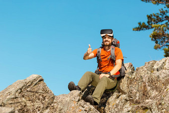 成功的年轻的男人。虚拟现实护目镜之旅山假期夏天