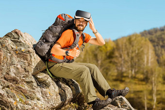 成功的年轻的男人。虚拟现实护目镜之旅山假期夏天