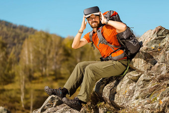 成功的年轻的男人。虚拟现实护目镜之旅山假期夏天