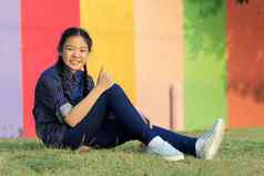 亚洲女孩放松坐着绿色草场公共公园