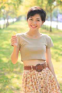 肖像年轻的美丽的亚洲女人站公园白