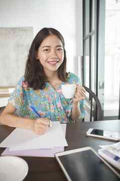 亚洲女人写作笔白色纸热饮料杯