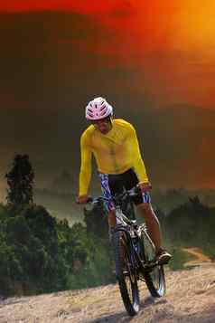 年轻的男人。骑山自行车自行车穿越山山